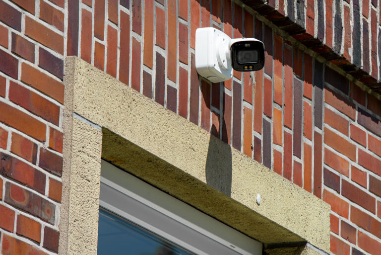 Das Bild zeigt eine TURM IP 4MP Bullet Kamera an der Außenseite eines Gebäudes.