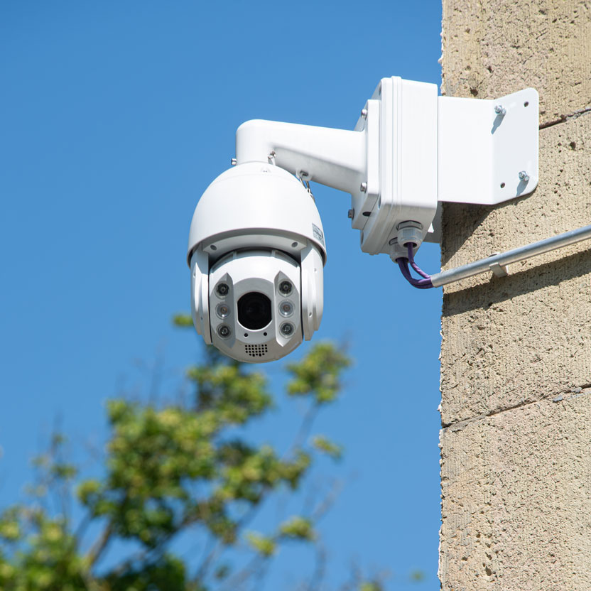 Das Bild zeigt eine TURM IP PTZ Kamera an der Außenseite eines Gebäudes.